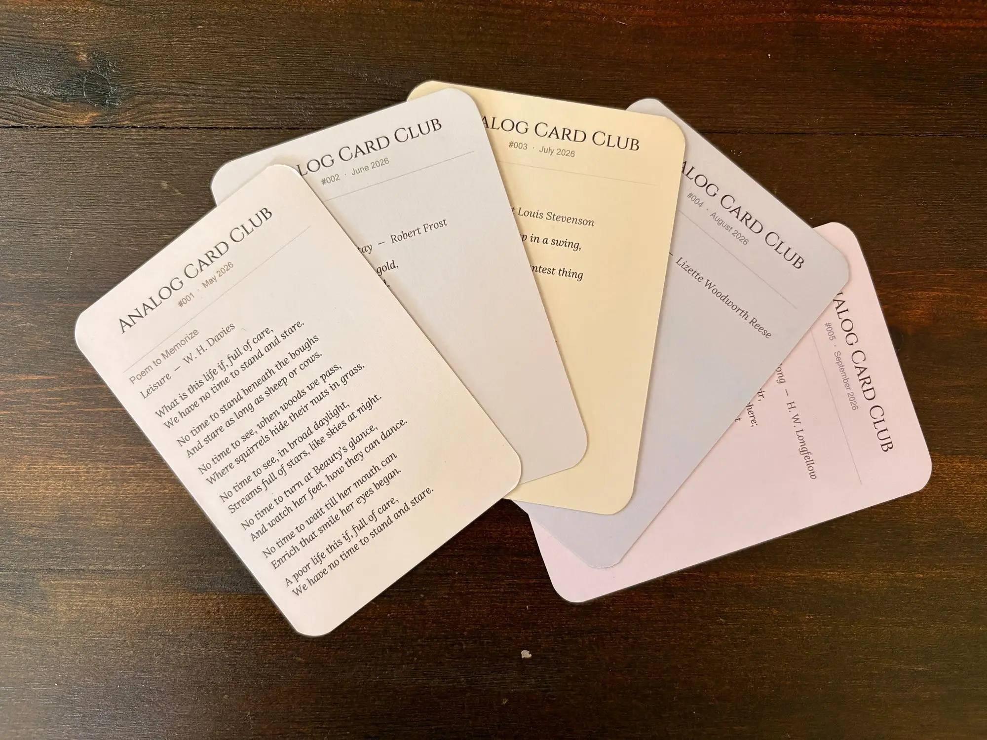 Five Analog Card Club cards spread across a wooden table